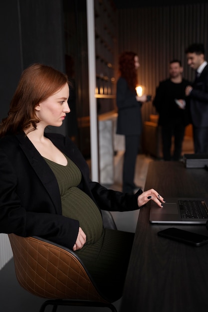 Giovane donna incinta al lavoro