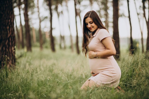 Giovane donna incinta in una foresta