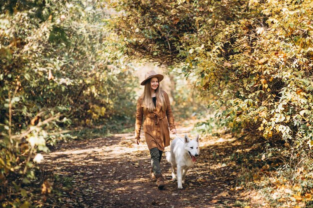 Giovane donna nel parco con il suo cane bianco