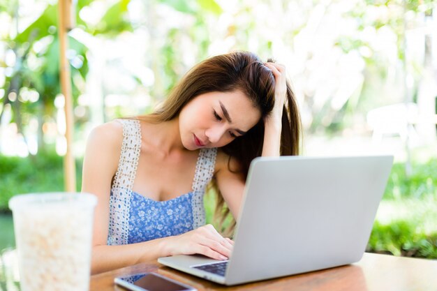 Giovane donna noiosa mentre uso laptop