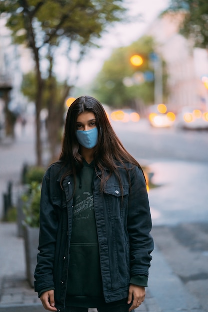 Giovane donna, persona in maschera sterile medica protettiva in strada vuota