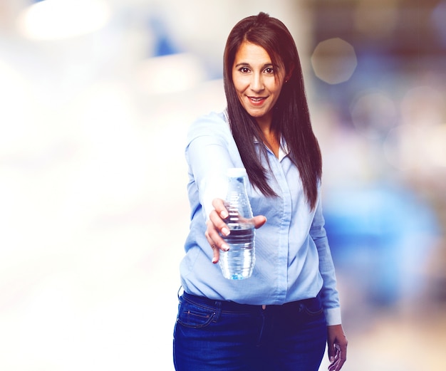 giovane donna positiva che mostra una bottiglia d&#39;acqua