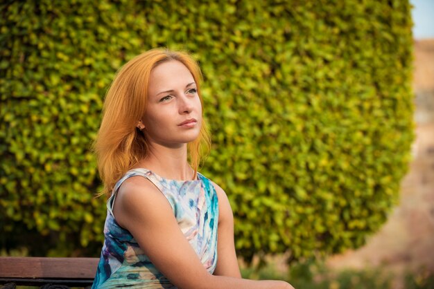 Giovane donna rossa su una panchina