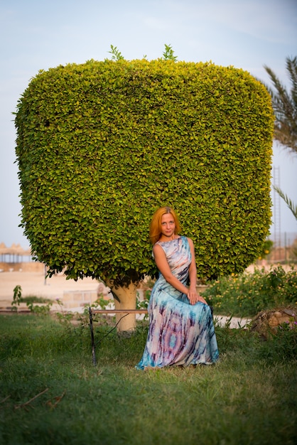 Giovane donna rossa su una panchina