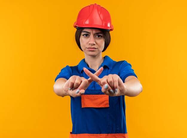 Giovane donna scontenta del costruttore in uniforme che mostra gesto di no