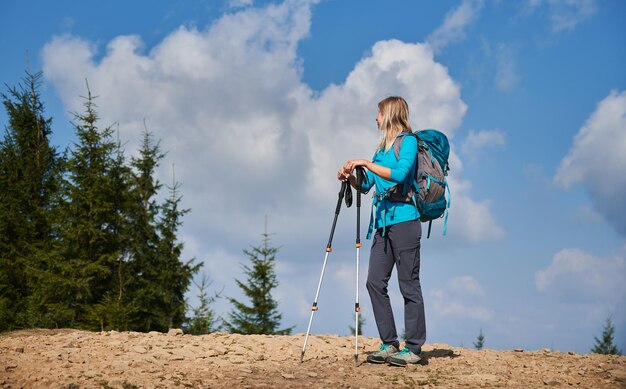 Giovane donna sola che fa un'escursione nell'aria fresca di montagna in estate