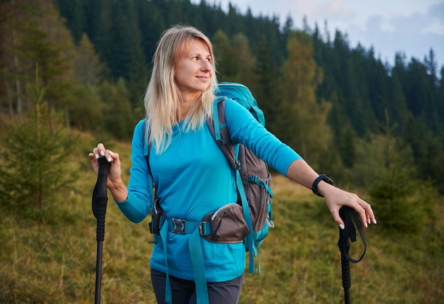 Giovane donna sola che fa un'escursione nell'aria fresca di montagna