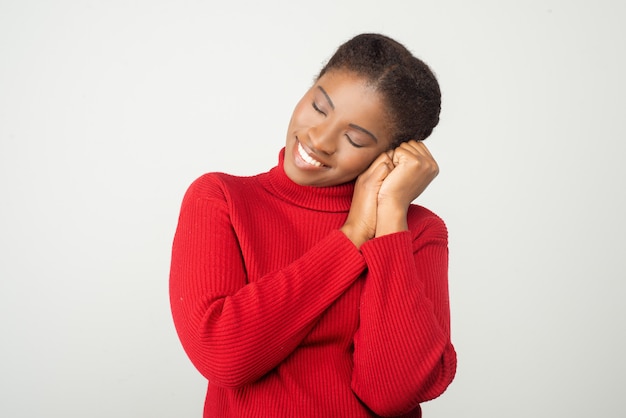 Giovane donna sorridente che mostra gesto di sonno