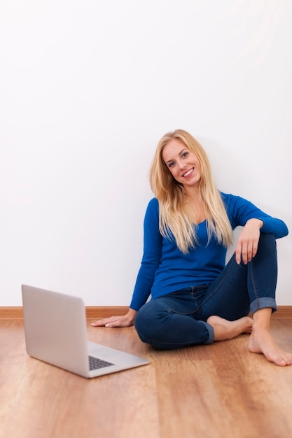 Giovane donna sorridente che si rilassa con il computer portatile