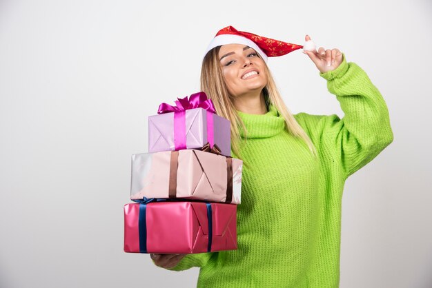 Giovane donna sorridente che tiene in mano i regali di Natale festivi