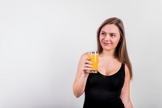 Giovane donna sorridente con vetro di succo