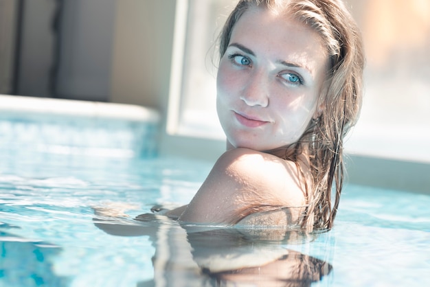 Giovane donna sorridente in piscina