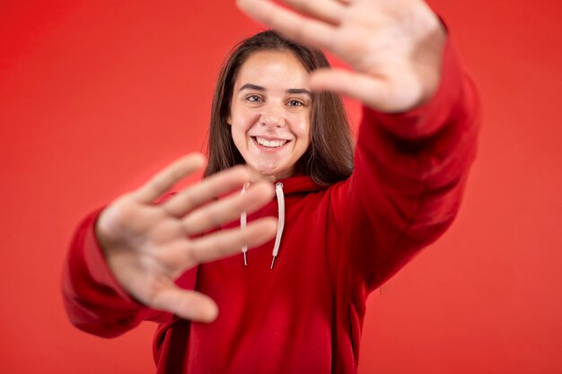 Giovane donna sorridente isolata su red