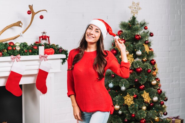 Giovane donna sorridente nel cappello di Natale