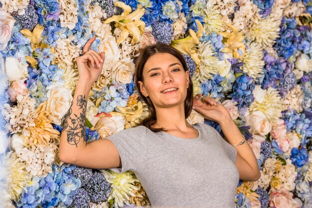 Giovane donna sorridente tra fiori diversi