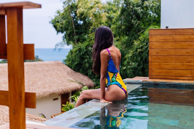 Giovane donna sottile felice abbastanza positiva in costume da bagno colorato in villa di lusso incredibile hotel godendo bella giornata in vacanza in Thailandia