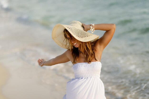 Giovane donna spensierata che si sente libera e si diverte in spiaggia