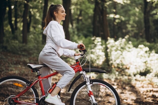 Giovane donna sportiva che guida la bicicletta nel parco