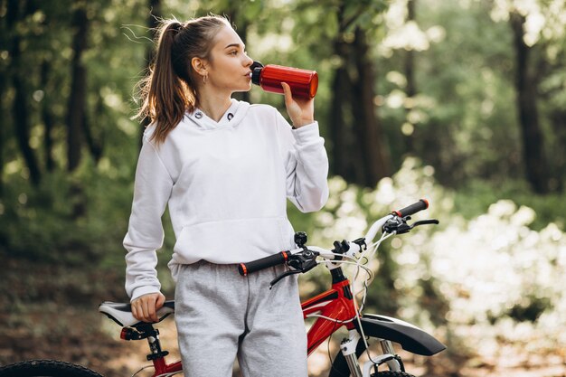Giovane donna sportiva che guida la bicicletta nel parco