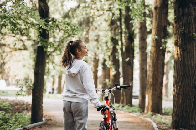 Giovane donna sportiva che guida la bicicletta nel parco