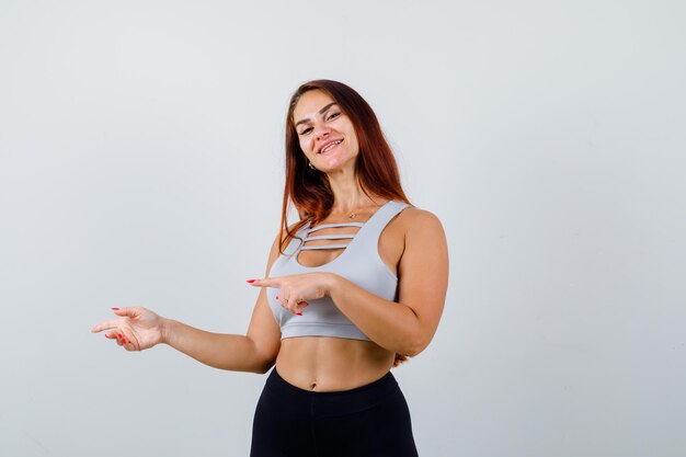 Giovane donna sportiva con i capelli lunghi in un top grigio