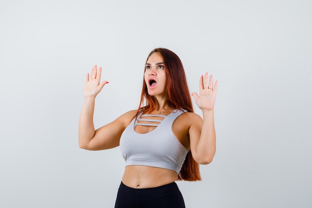 Giovane donna sportiva con i capelli lunghi in un top grigio