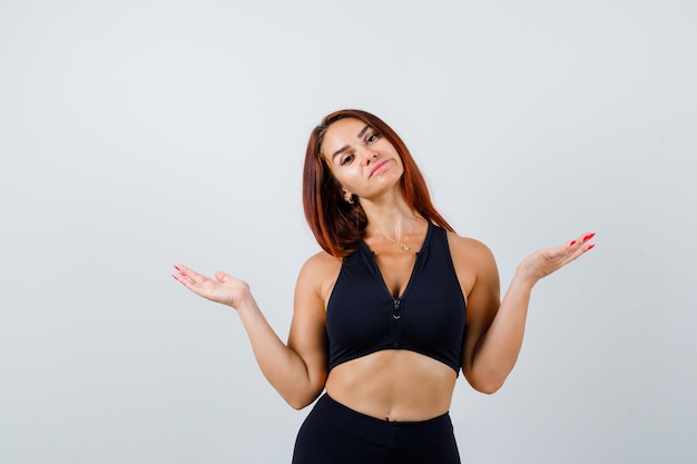 Giovane donna sportiva con i capelli lunghi in un top nero