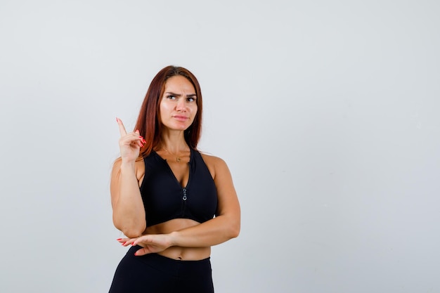 Giovane donna sportiva con i capelli lunghi in un top nero