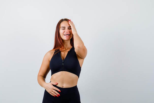 Giovane donna sportiva con i capelli lunghi in un top nero