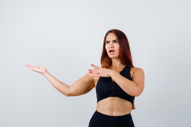 Giovane donna sportiva con i capelli lunghi in un top nero