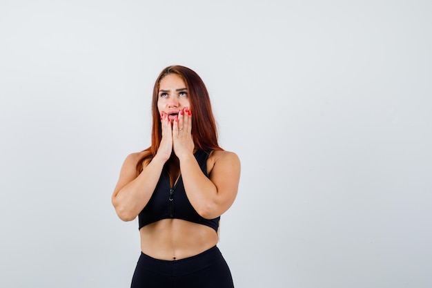 Giovane donna sportiva con i capelli lunghi in un top nero