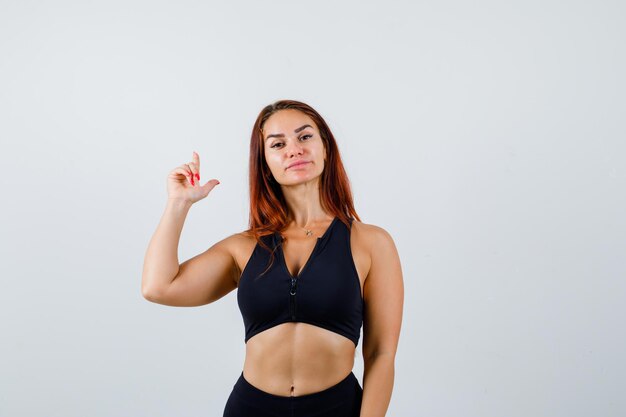 Giovane donna sportiva con i capelli lunghi in un top nero