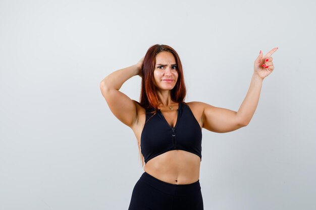 Giovane donna sportiva con i capelli lunghi in un top nero