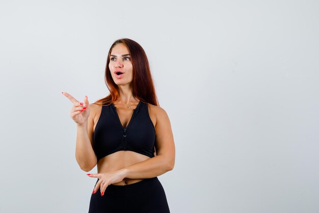 Giovane donna sportiva con i capelli lunghi in un top nero