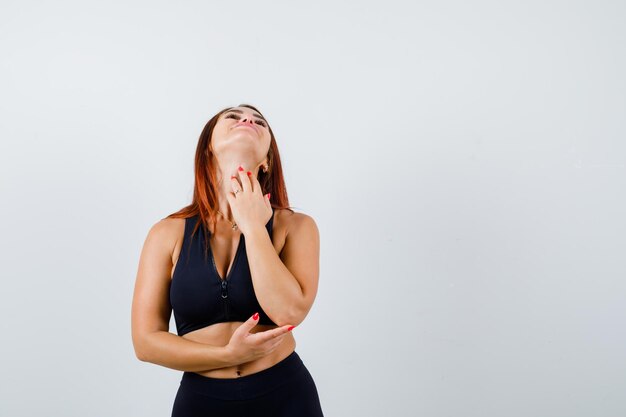 Giovane donna sportiva con i capelli lunghi in un top nero