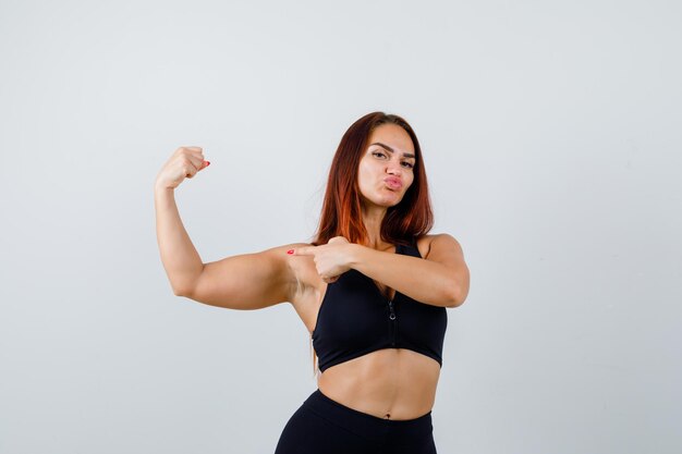 Giovane donna sportiva con i capelli lunghi in un top nero