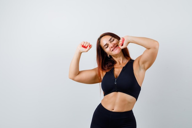 Giovane donna sportiva con i capelli lunghi in un top nero