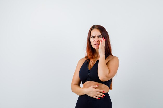 Giovane donna sportiva con i capelli lunghi in un top nero