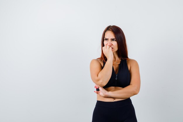 Giovane donna sportiva con i capelli lunghi in un top nero