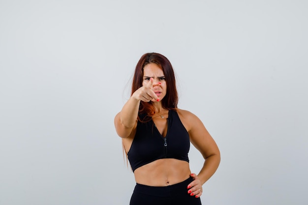 Giovane donna sportiva con i capelli lunghi in un top nero