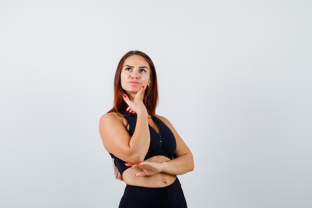 Giovane donna sportiva con i capelli lunghi in un top nero