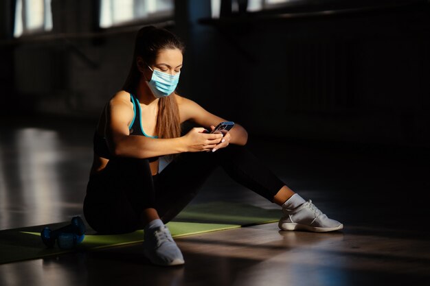 Giovane donna sportiva dopo aver praticato lo yoga, interrompe l'esercizio, si rilassa sul tappetino da yoga