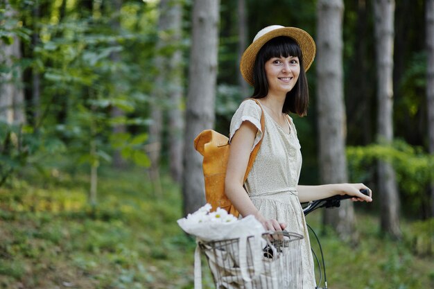 Giovane donna su sfondo di natura con bici