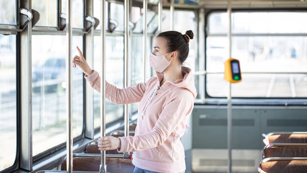 giovane donna sui trasporti pubblici durante la pandemia.