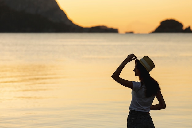 Giovane donna sul tramonto sulla riva di un lago