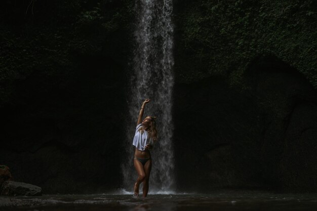 giovane donna viaggia per l'isola per scattare foto a una cascata