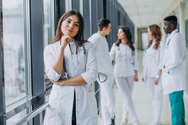 Giovane dottoressa in posa nel corridoio dell'ospedale