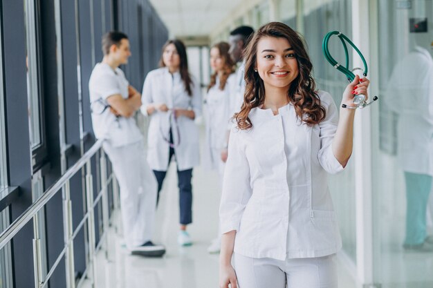 Giovane dottoressa in posa nel corridoio dell'ospedale