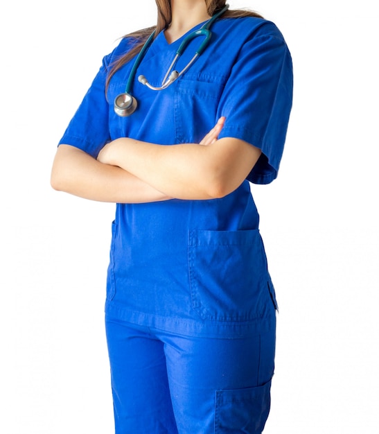 Giovane dottoressa in uniforme medica blu in piedi con sicurezza con le mani incrociate