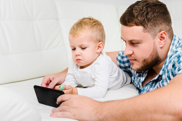 Giovane e bambino che giocano su smartphone